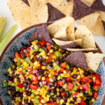 Black Bean and corn Salsa in a serving bowl with tortilla chips.