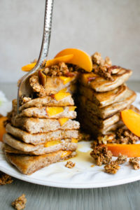 A stack of Peach Pancakes, cut and on a fork.