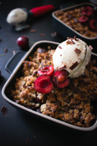 Chocolate cherry crumble with sweet, juicy cherries topped with a crunchy topping filled with chocolate chips. Topped with a scoop of vanilla ice cream.