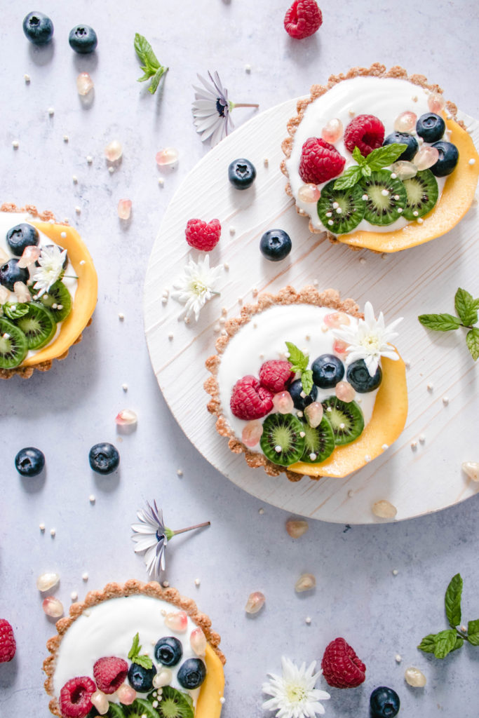 gluten free fruit tart made of a granola crust filled with Yogurt and topped with berries
