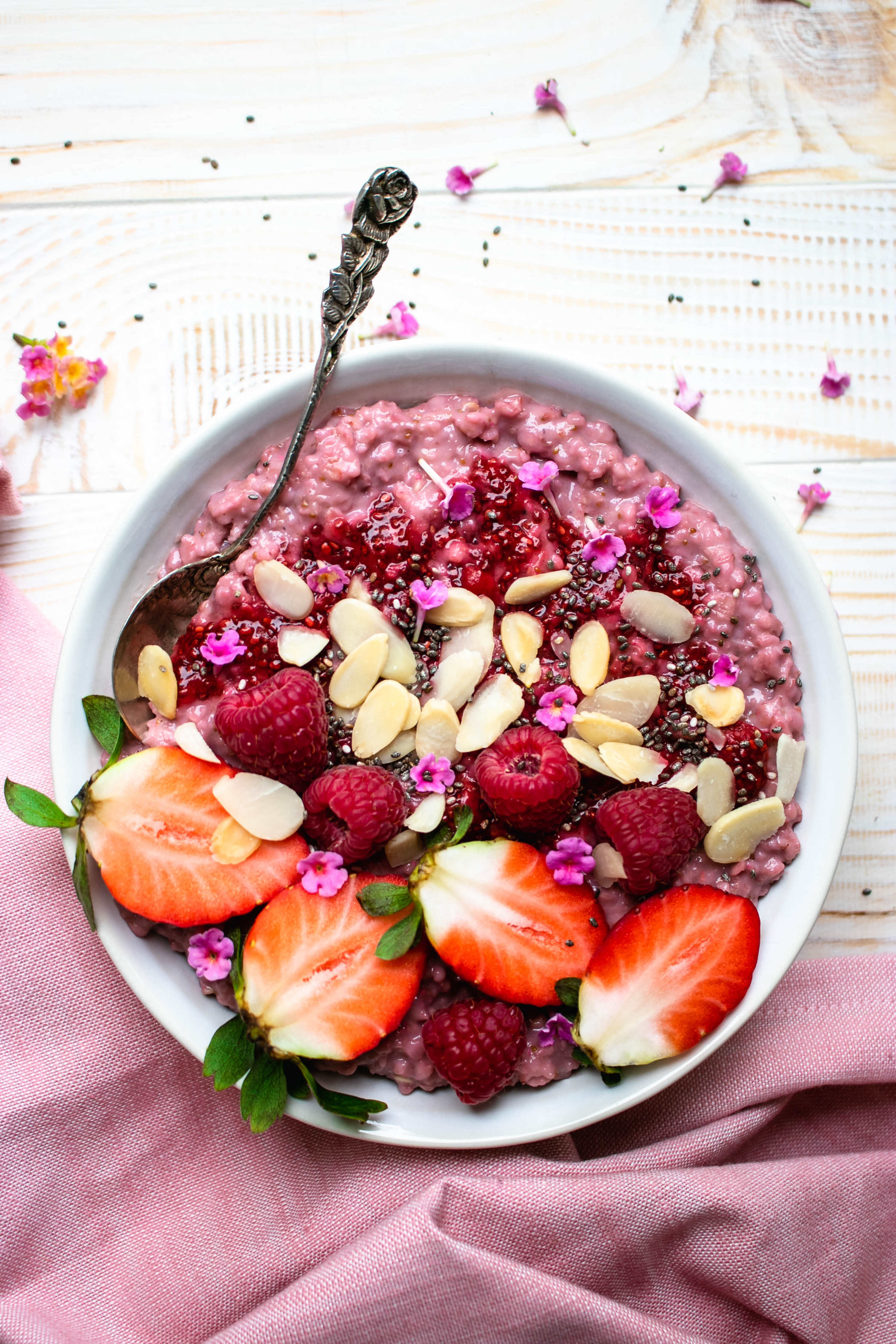 Strawberry Banana Oatmeal served in a bowl topped with fresh berries and almonds.
