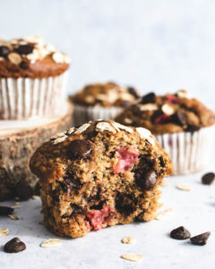 close up of oat banana muffin with chocolate chips and strawberries