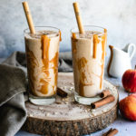 Apple Pie Smoothie served with caramel sauce served in two tall glasses.
