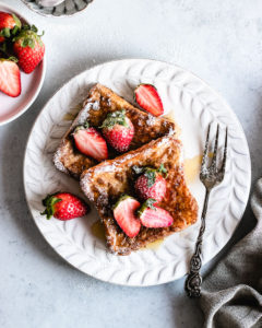 Easy Vegan French Toast served with fresh strawberries and maple syrup.