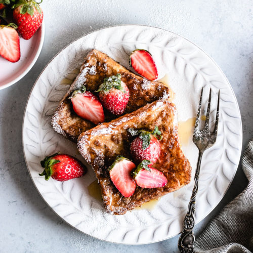 Easy Vegan French Toast served with fresh strawberries and maple syrup.
