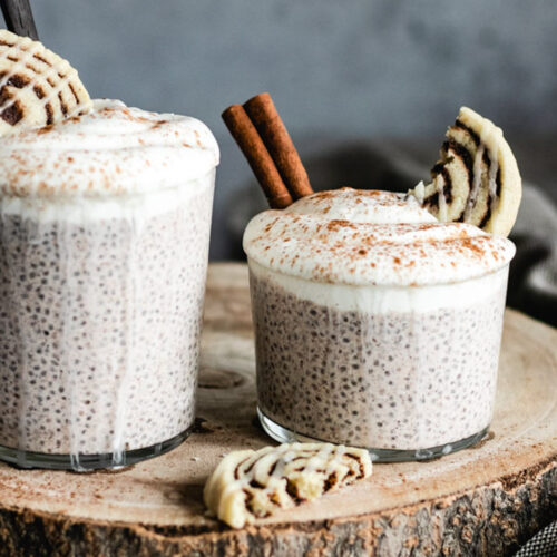 The Chia Pudding in two glasses topped with yoghurt and a dusting of cinnamon.
