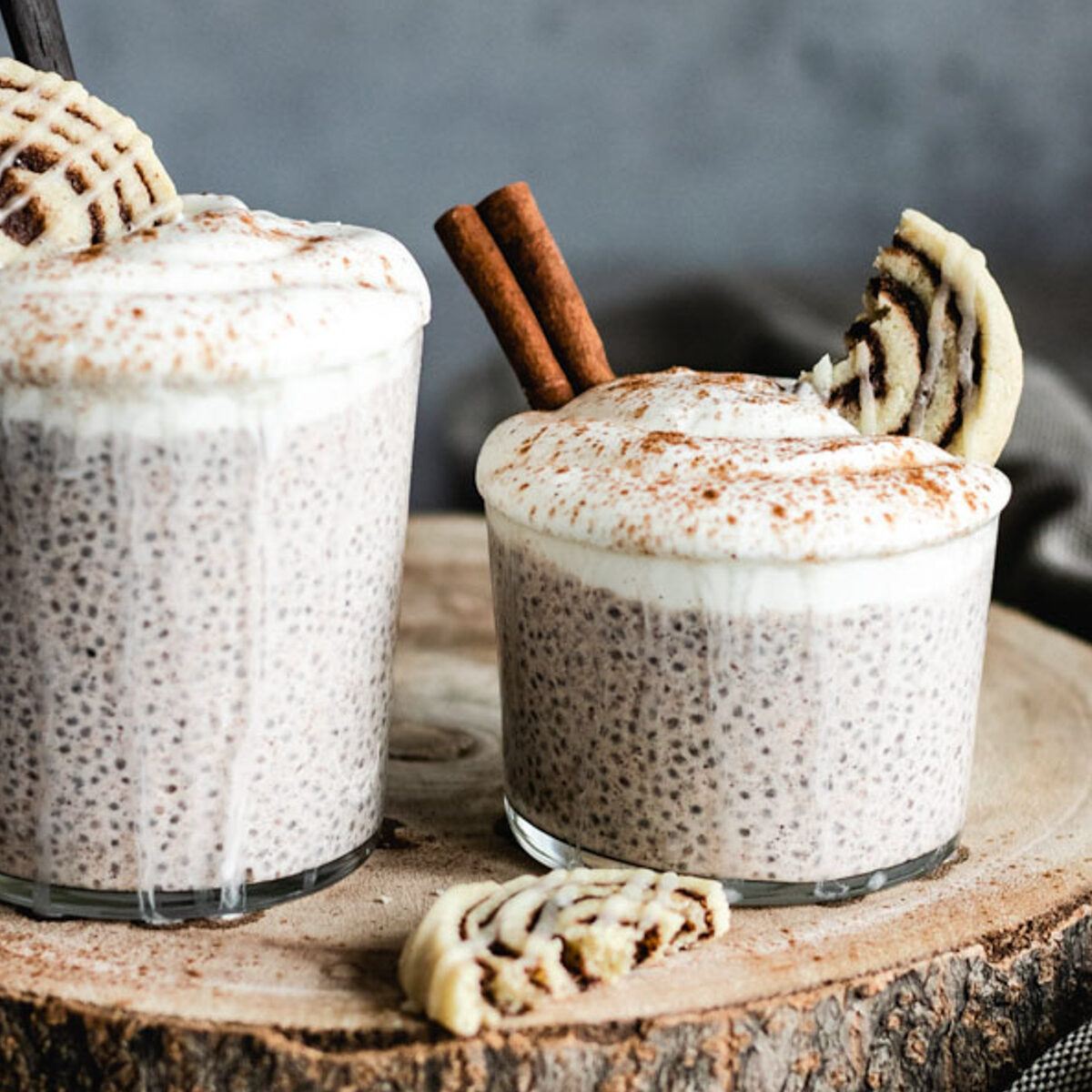 The Chia Pudding in two glasses topped with yoghurt and a dusting of cinnamon.