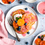 Blood Orange Vegan Pancakes topped with orange slices, yoghurt and blueberries.