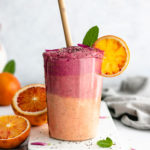 Healthy Beet and Blood Orange Smoothie served in a big glass with a slice of blood orange.