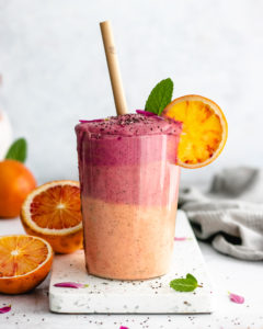 Healthy Beet and Blood Orange Smoothie served in a big glass with a slice of blood orange.