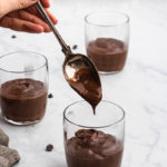 filling chocolate pudding into glasses