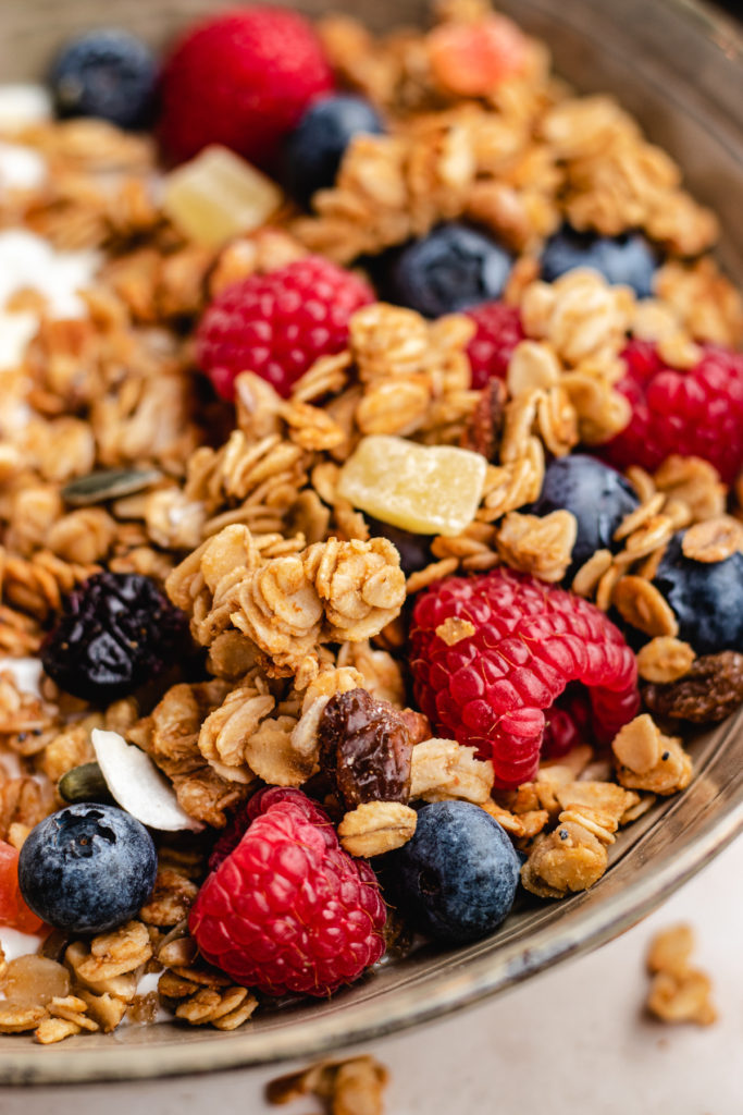 closeup of the air fryer granola in a bowl with yoghurt and fresh berries
