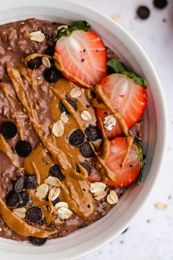 protein chocolate overnight oats served in a bowl with toppings. 