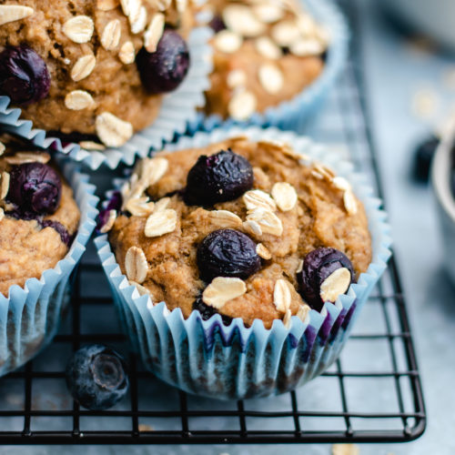 Banana blueberry oatmeal muffins on a cooling rack.