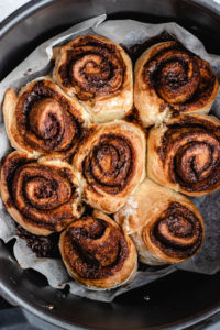 The cooked cinnamon rolls in the air fryer basket.