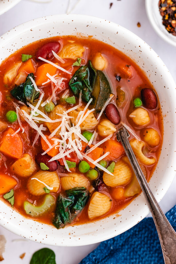 Vegan Minestrone Soup full of vegetables served in a bowl with bread.