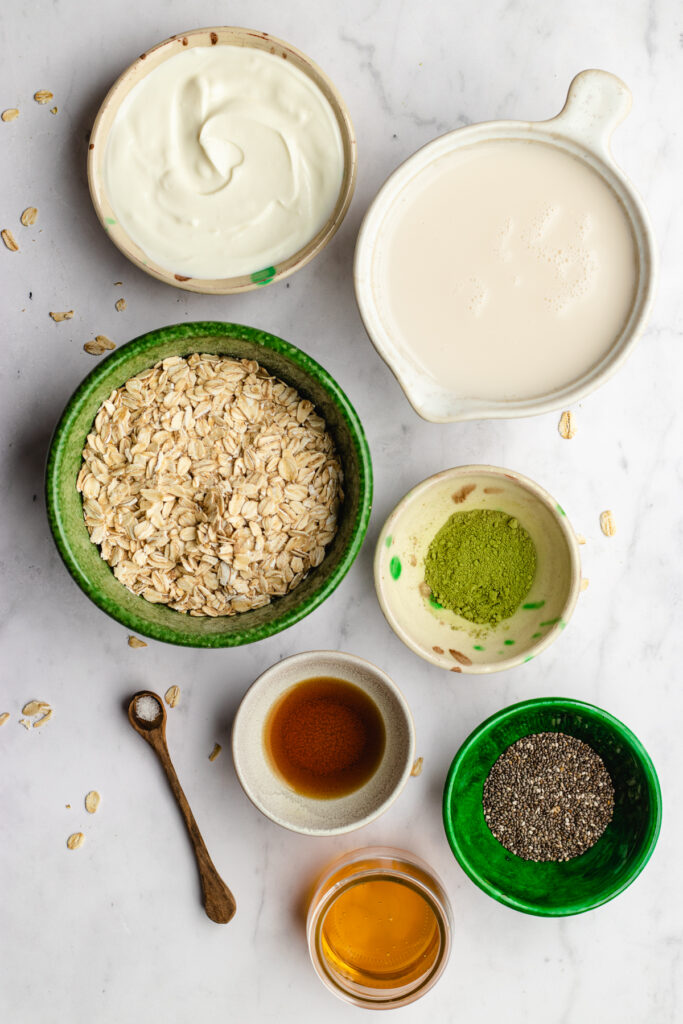 Small bowls with the ingredients needed to make this matcha overnight oats.