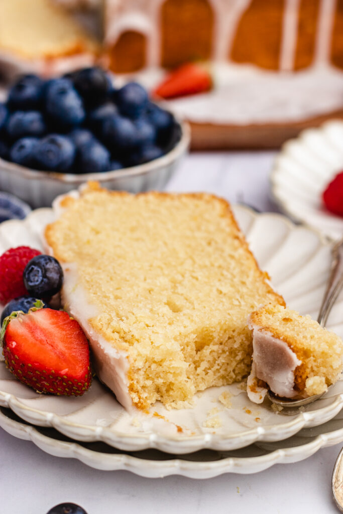 A slice of Vegan Pound Cake topped served on a plate. Cut with a small spoon. 
