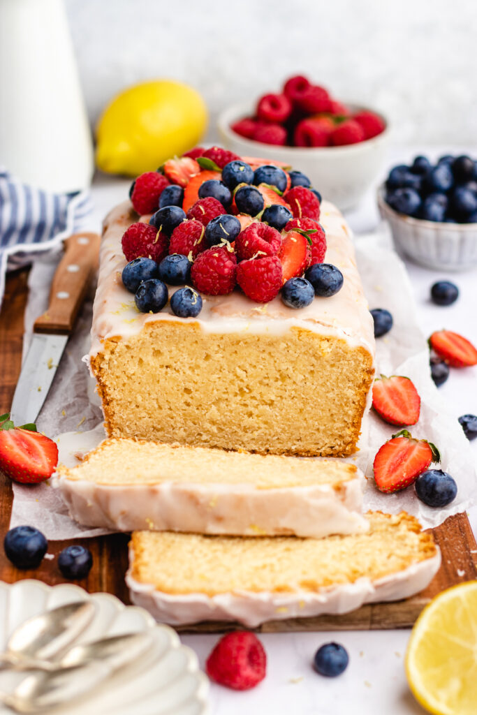 Vegan Pound Cake topped with a lemon glaze and berries on top. Cut into slices.