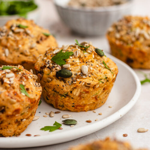 Savoury muffins topped with seeds, presented on a plate.