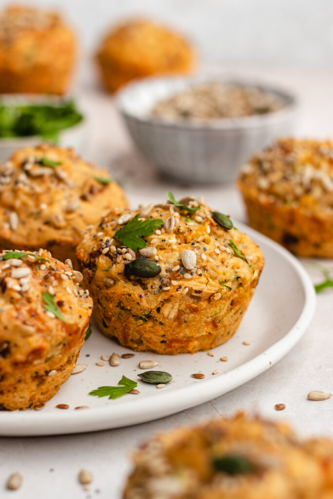 Savory muffins topped with seeds, presented on a plate.