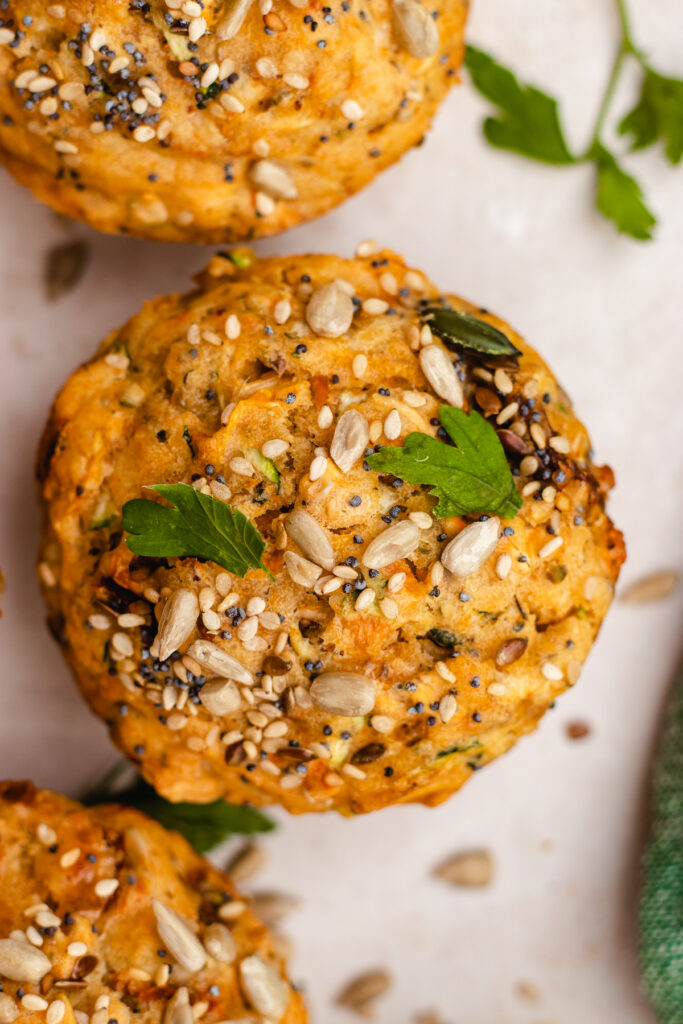 3 Savoury muffins topped with seeds and some herbs.