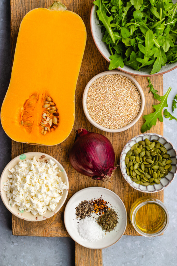 Ingredients for this Quinoa salad presented on a wooden cutting board.