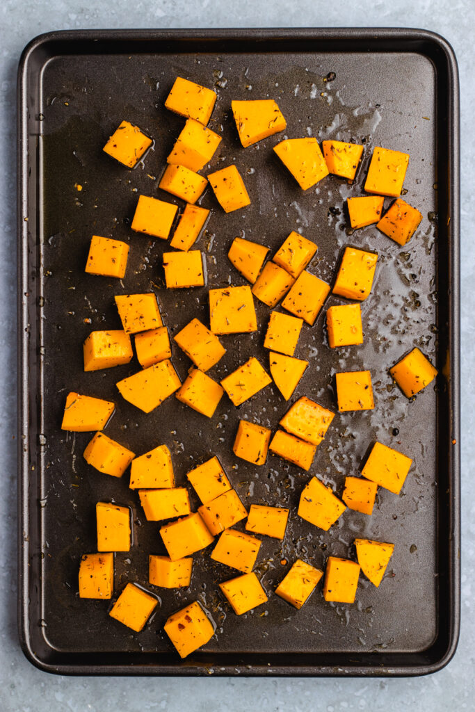 Pieces of pumpkin on a baking tray.