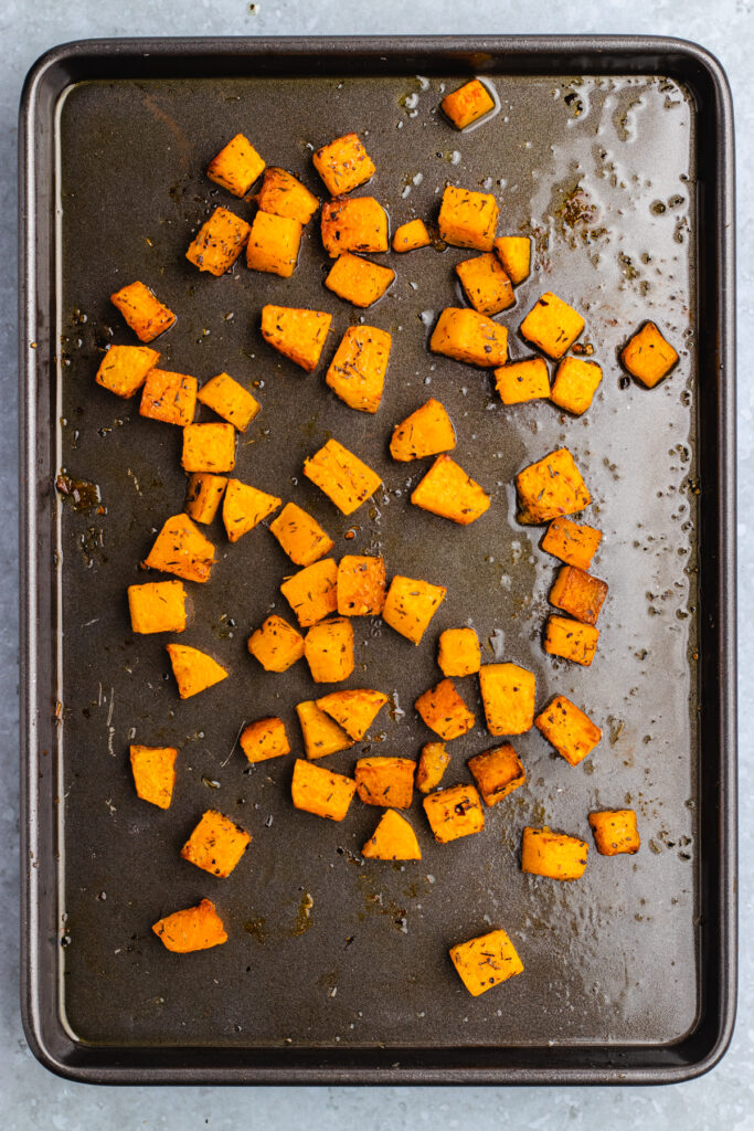 Roasted Pieces of pumpkin on a baking tray.