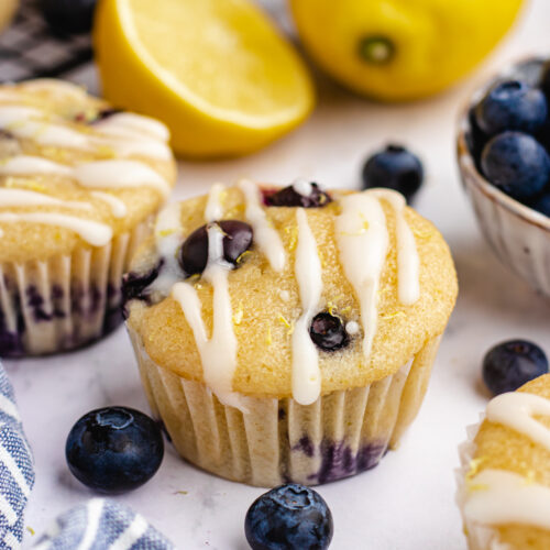 Vegan blueberry lemon muffins topped with icing.
