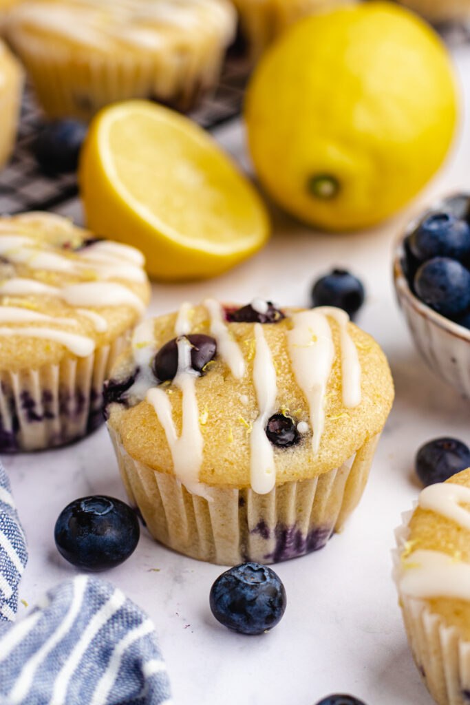 Vegan blueberry lemon muffins topped with icing.