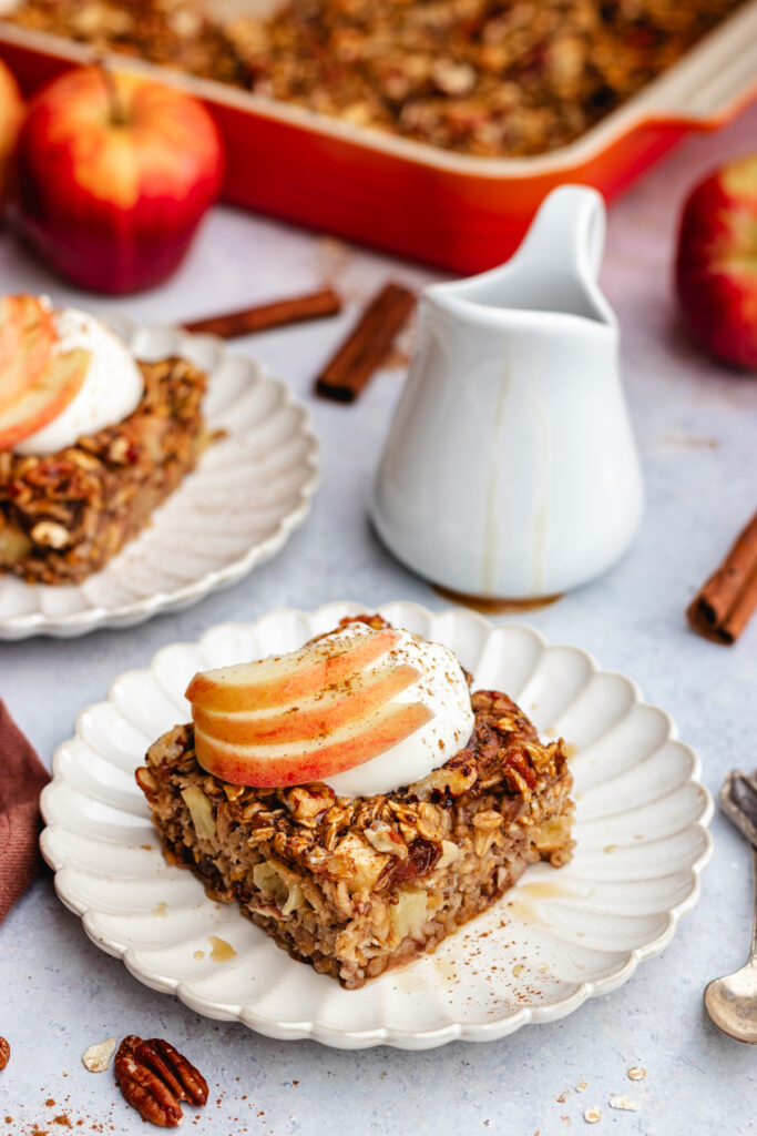 Slices of Apple pie baked oats topped with yoghurt and apple slices.