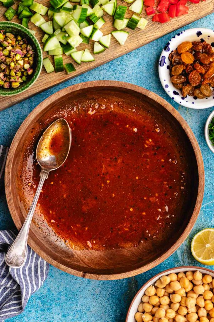 The dressing in a wooden salad bowl.