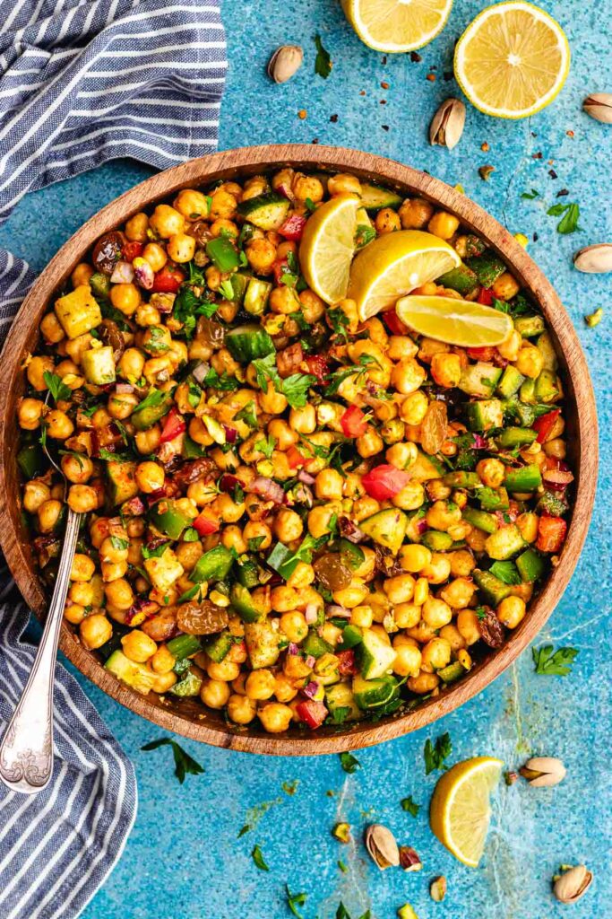 The Moroccan chickpea salad served in a wooden salad bowl topped with slices of lemon.