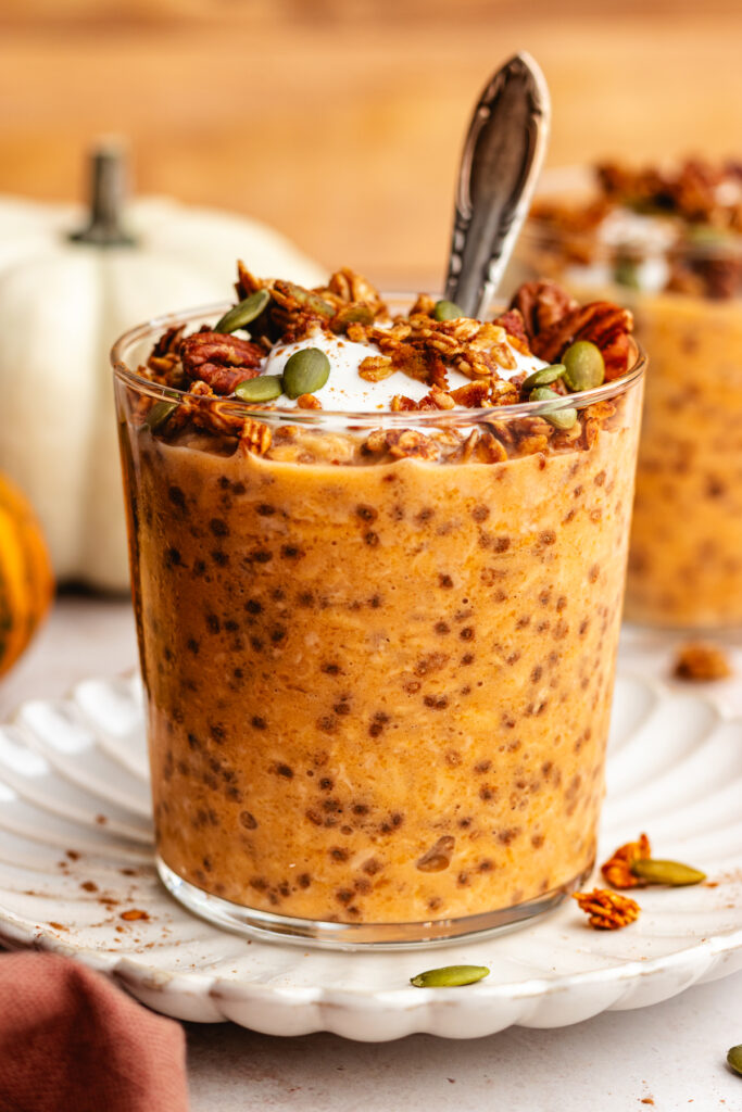 Pumpkin Pie Overnight Oats served in a glass topped with yoghurt and granola.