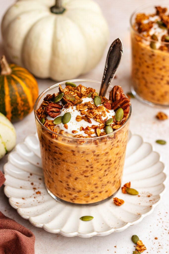 Pumpkin Pie Overnight Oats served in a glass topped with yoghurt and granola.