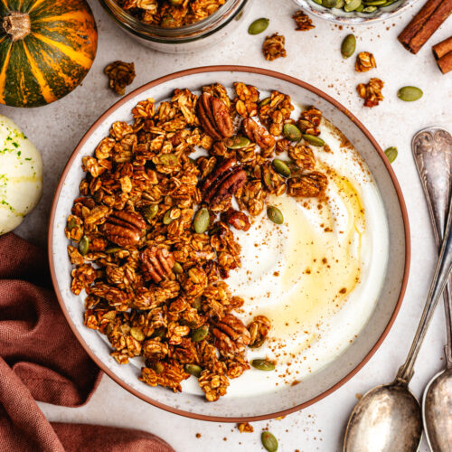 Pumpkin spice granola served in a bowl with some yoghurt.
