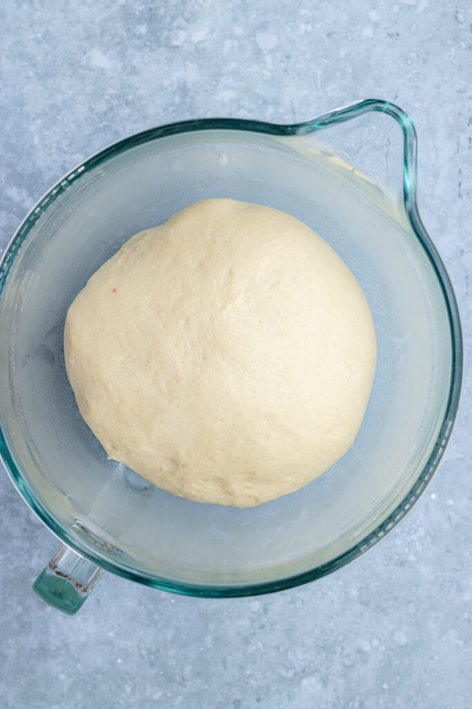 The dough in a glass bowl after rising.
