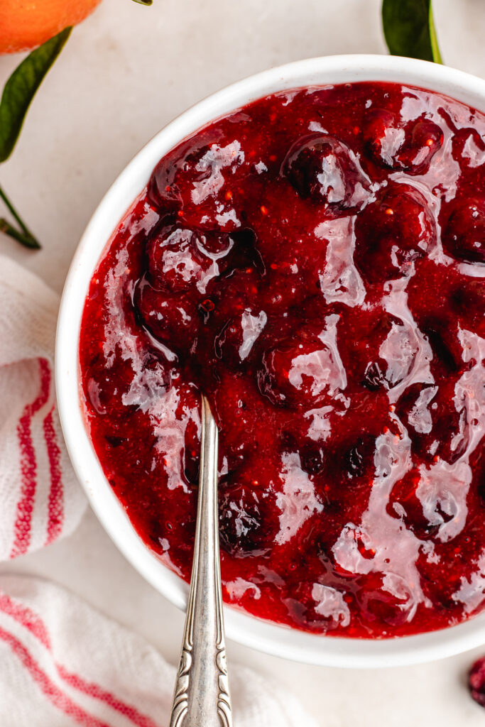 Cranberry sauce in a bowl with a spoon.