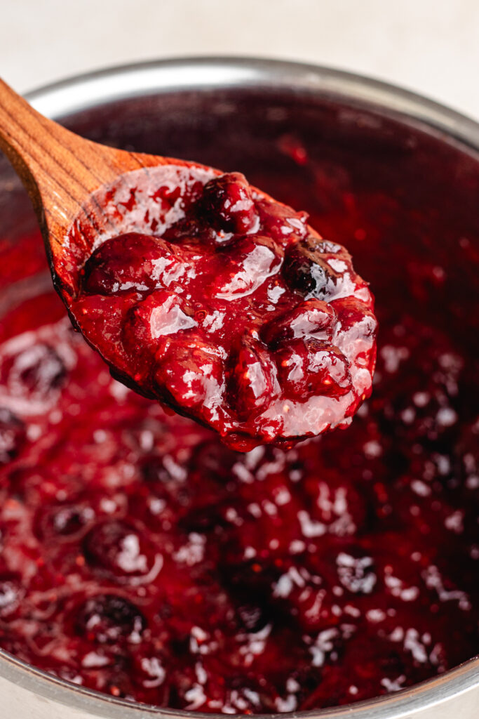 Cranberry sauce on a wooden spoon. 