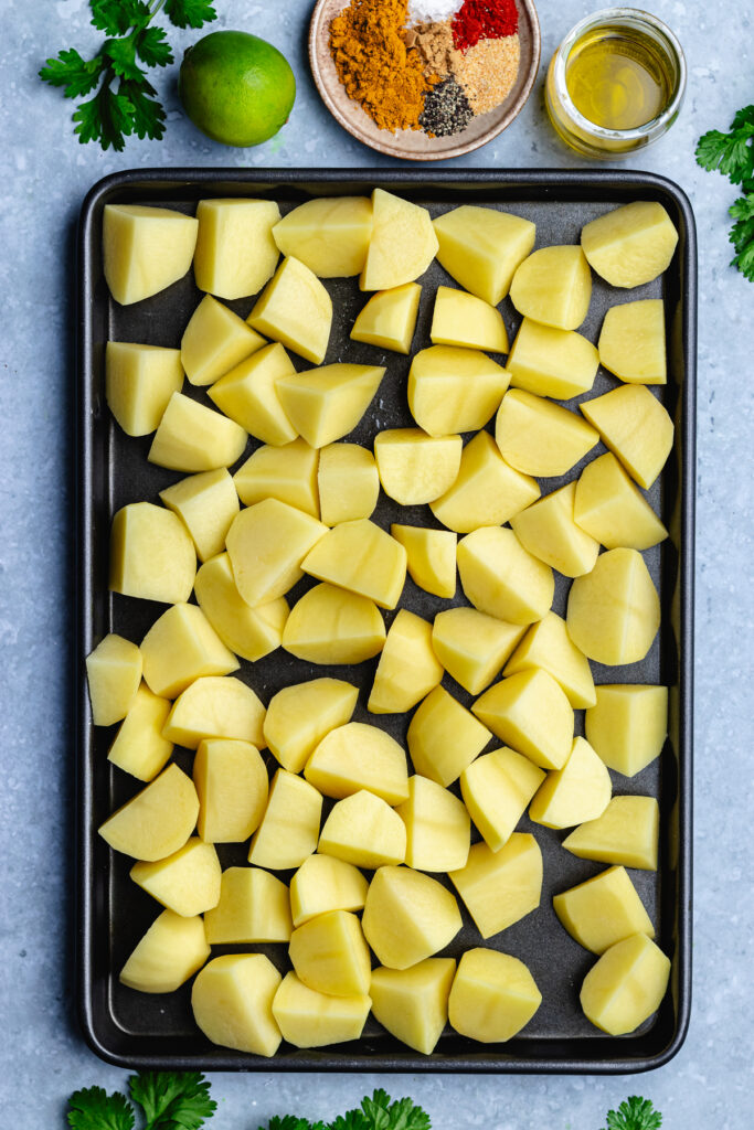 The cut potatoes on a baking tray.