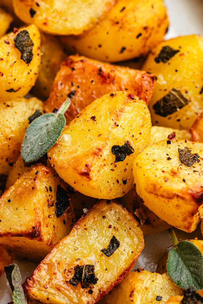 Closeup of the Roasted potatoes with sage topped with fresh sage leafs. 