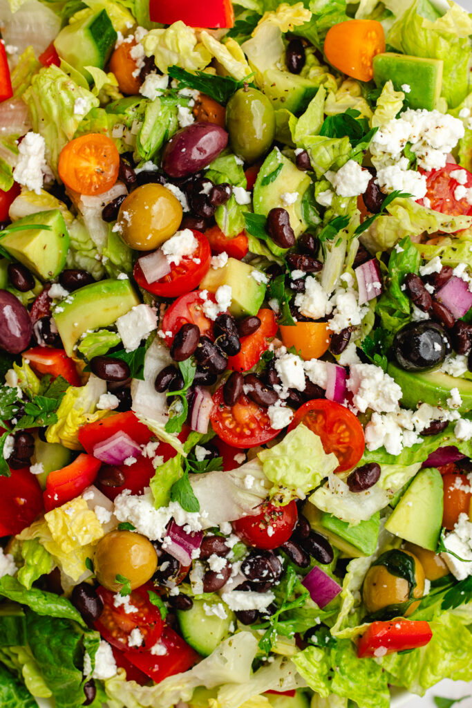 Topping the salad with feta cheese.