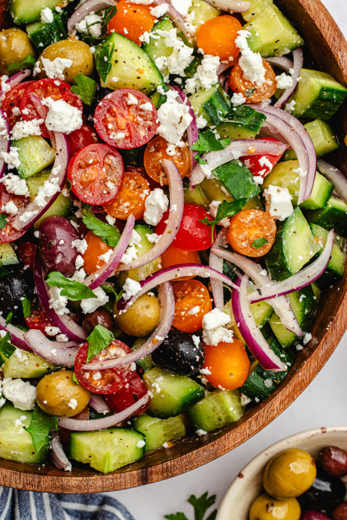Mediterranean tomato and cucumber salad served in a wooden salad bowl.