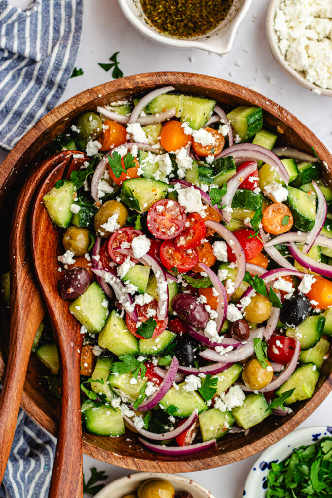 Mediterranean tomato and cucumber salad served in a wooden salad bowl.