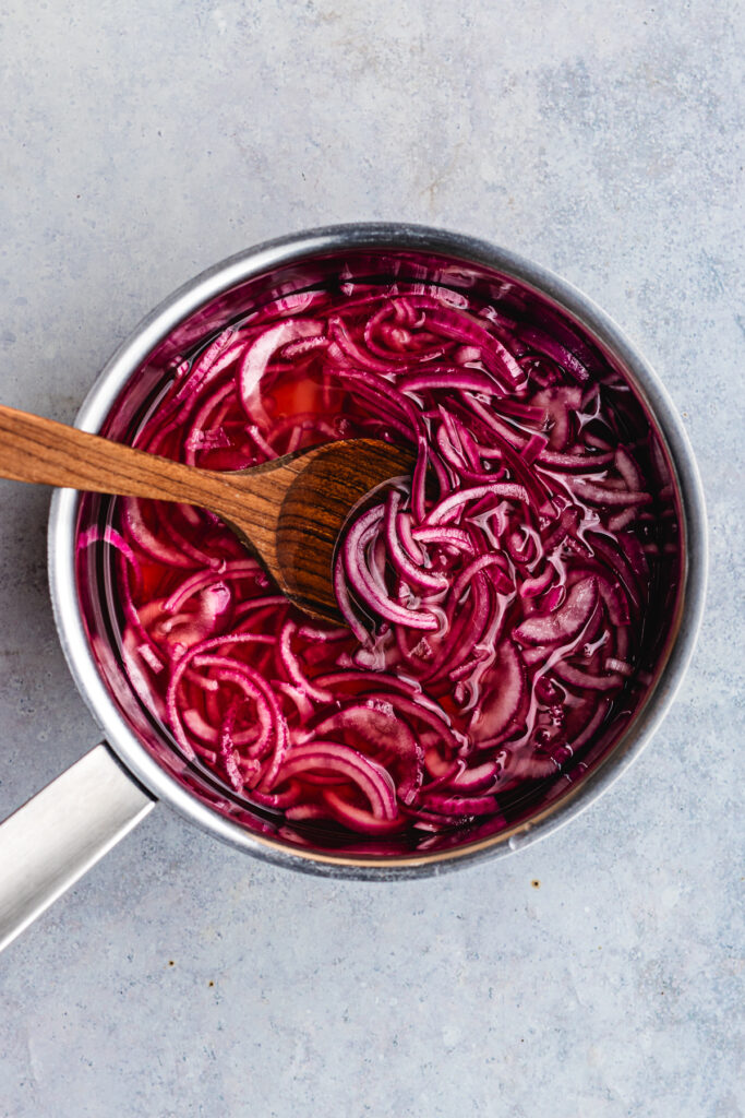 The pickling brine and red onions in a pan.