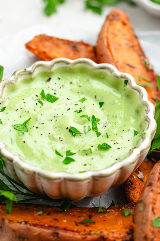 The Dressing in a small bowl topped with herbs. 