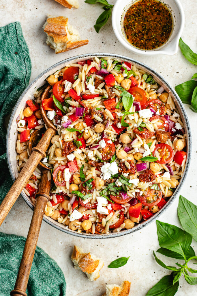 The salad in a big bowl with a bowl of dressing on the side.