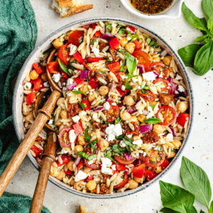 The salad in a big bowl with a bowl of dressing on the side.