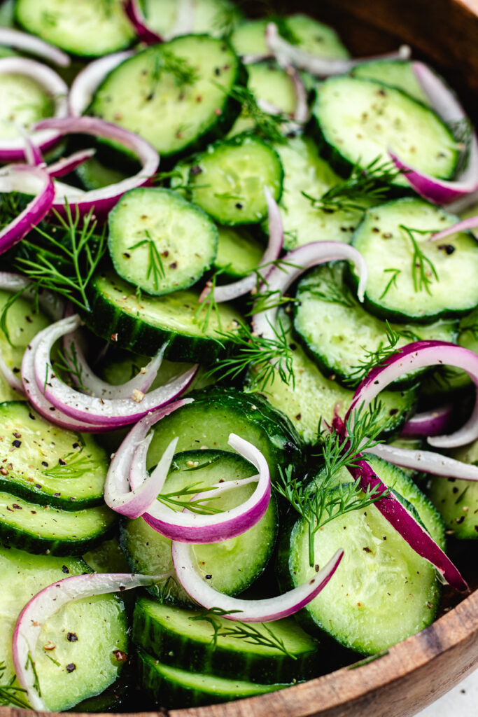 The salad topped with fresh dill in a wooden bowl.